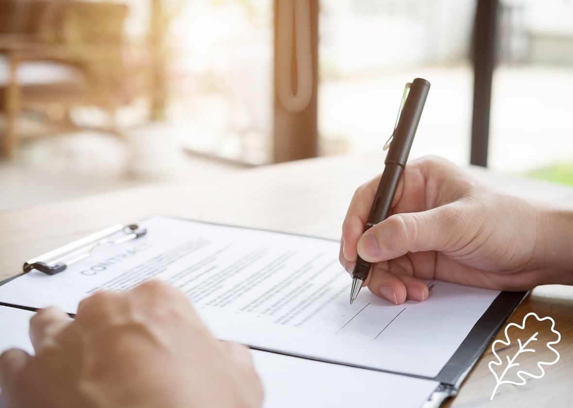 Hand shown signing a document
