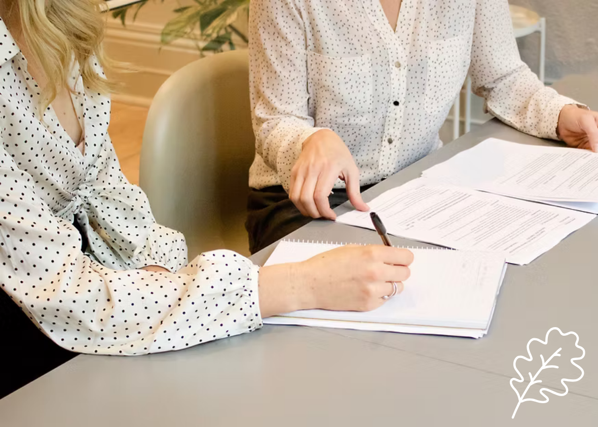 Woman guiding another woman through documents for mobile