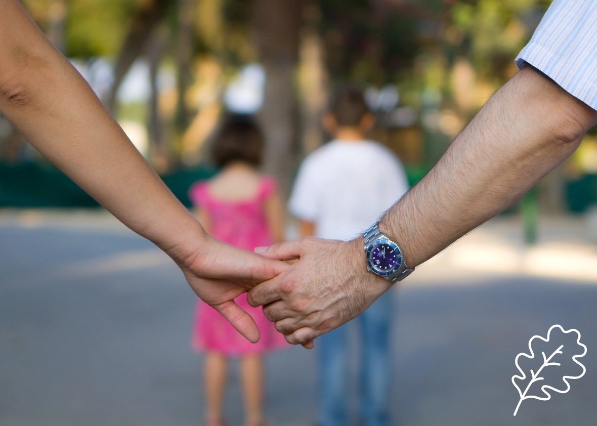 Couples' hands linked with their children walking ahead for mobile